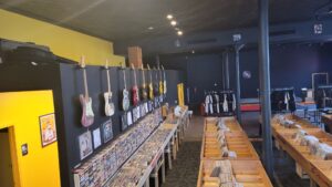 Interior view of Pizza Records, showing electric guitars on the wall and many vinyl records for sale.